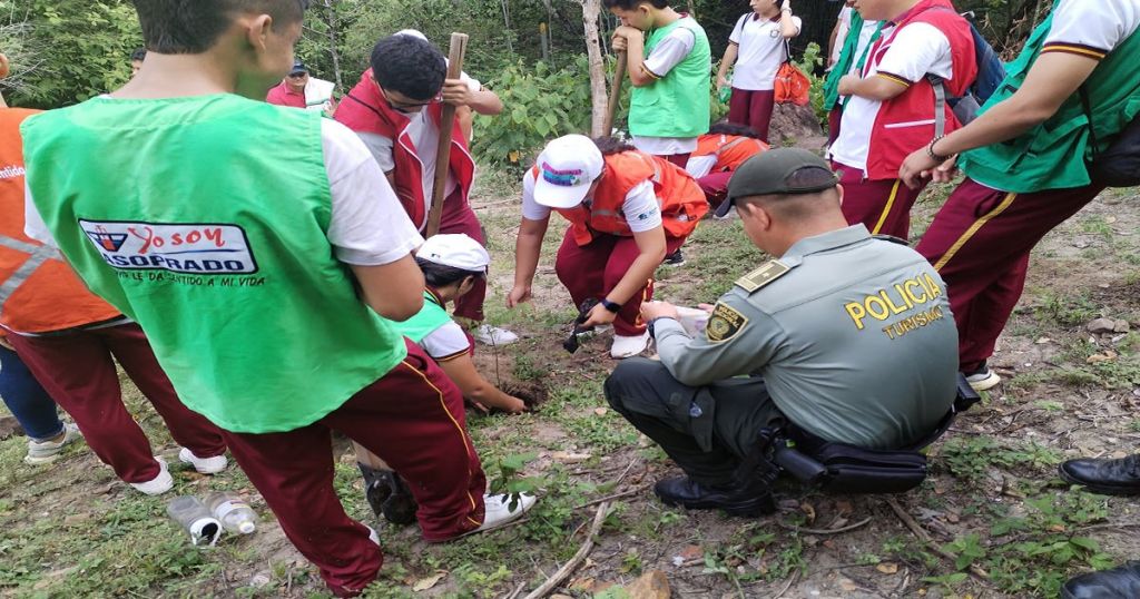 Policía y estudiantes trabajando por mejorar el verde en prado