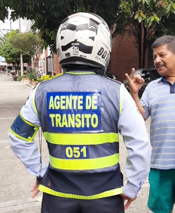 Agentes de tránsito azules recogen carros frente a casas de los dueños